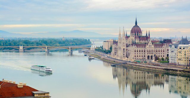 Quite Danube river, floating cruise ship, Parliament building. Budapest, Hungary